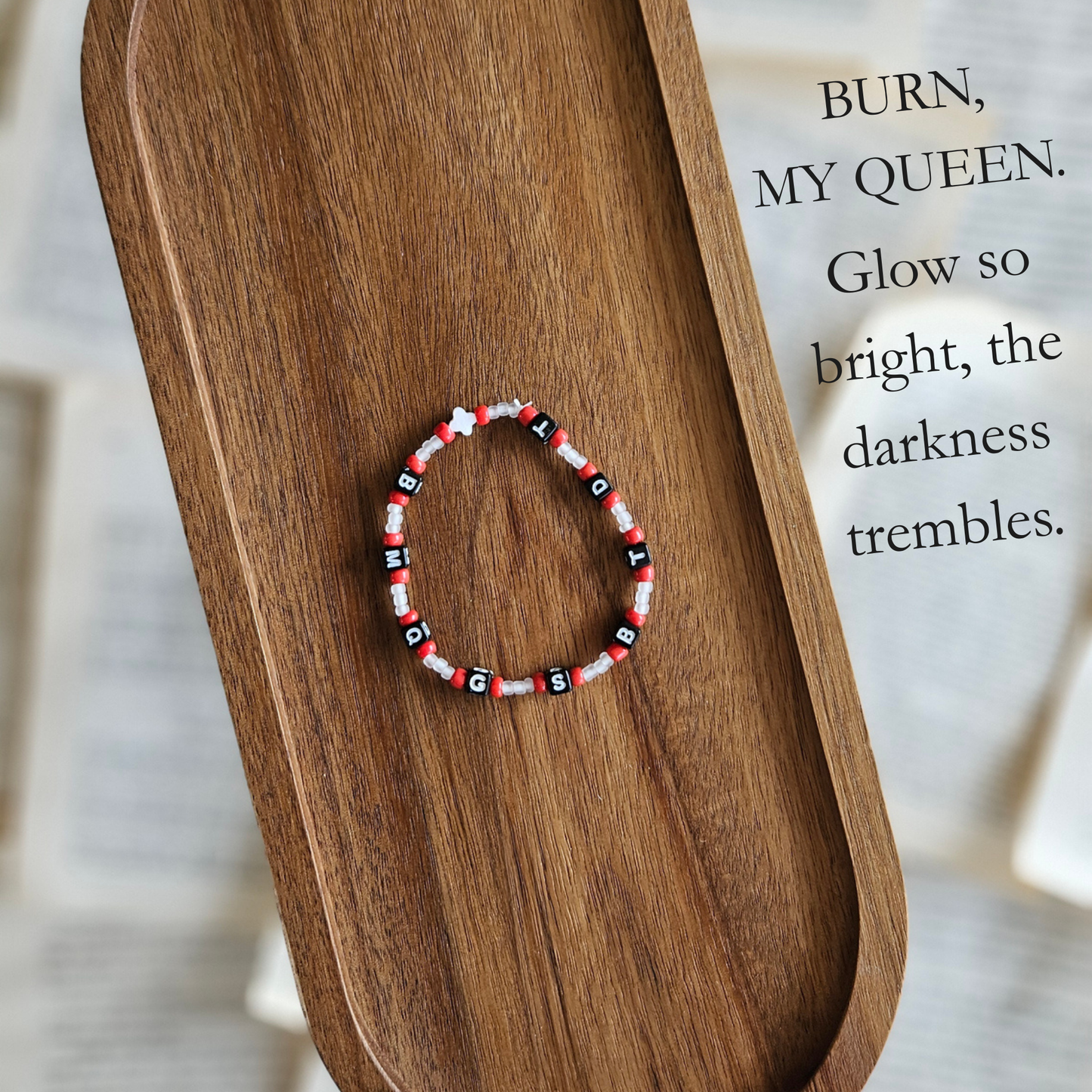 Beaded bracelet on a wooden surface with a quote in the background