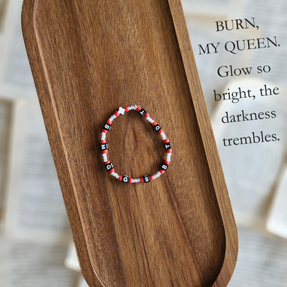Beaded bracelet on a wooden surface with a quote in the background