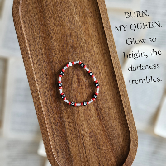 Beaded bracelet on a wooden surface with a quote in the background