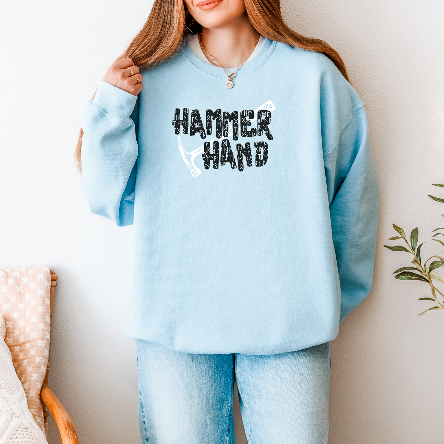 Person wearing a light blue sweatshirt with 'HAMMER HAND' text design.