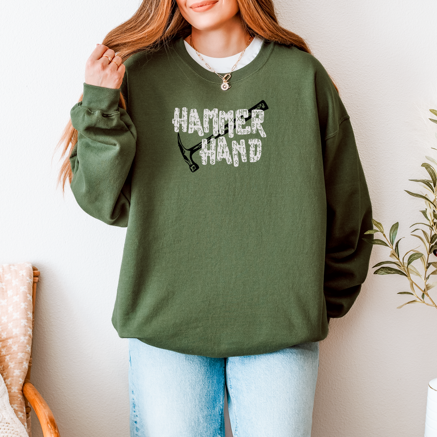 Person wearing a green sweatshirt with 'HAMMER HAND' text and graphic, standing against a neutral background.