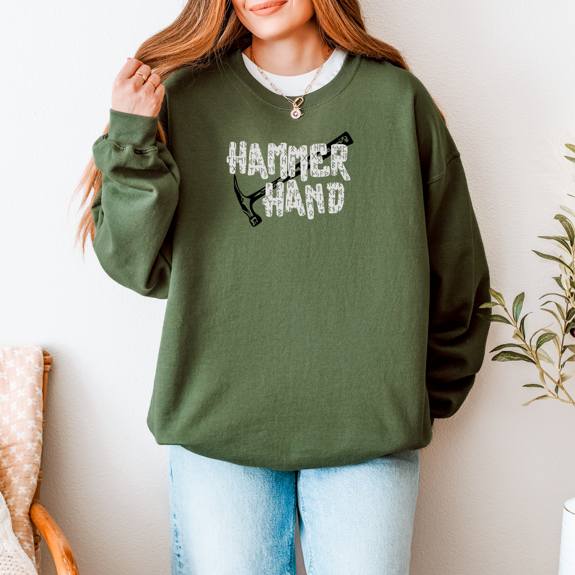Person wearing a green sweatshirt with 'HAMMER HAND' text and graphic, standing against a neutral background.