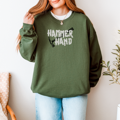 Person wearing a green sweatshirt with 'HAMMER HAND' text and graphic, standing against a neutral background.