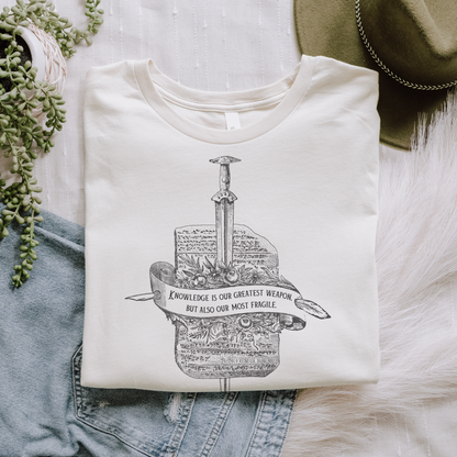 Flatlay of soft cream Knowledge tee, inspired by Orin Steele