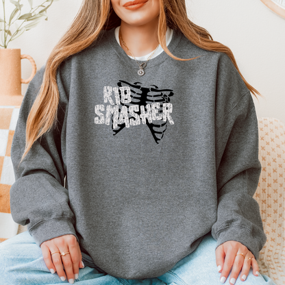 Person wearing a gray sweatshirt with 'Rib Smasher' graphic design.
