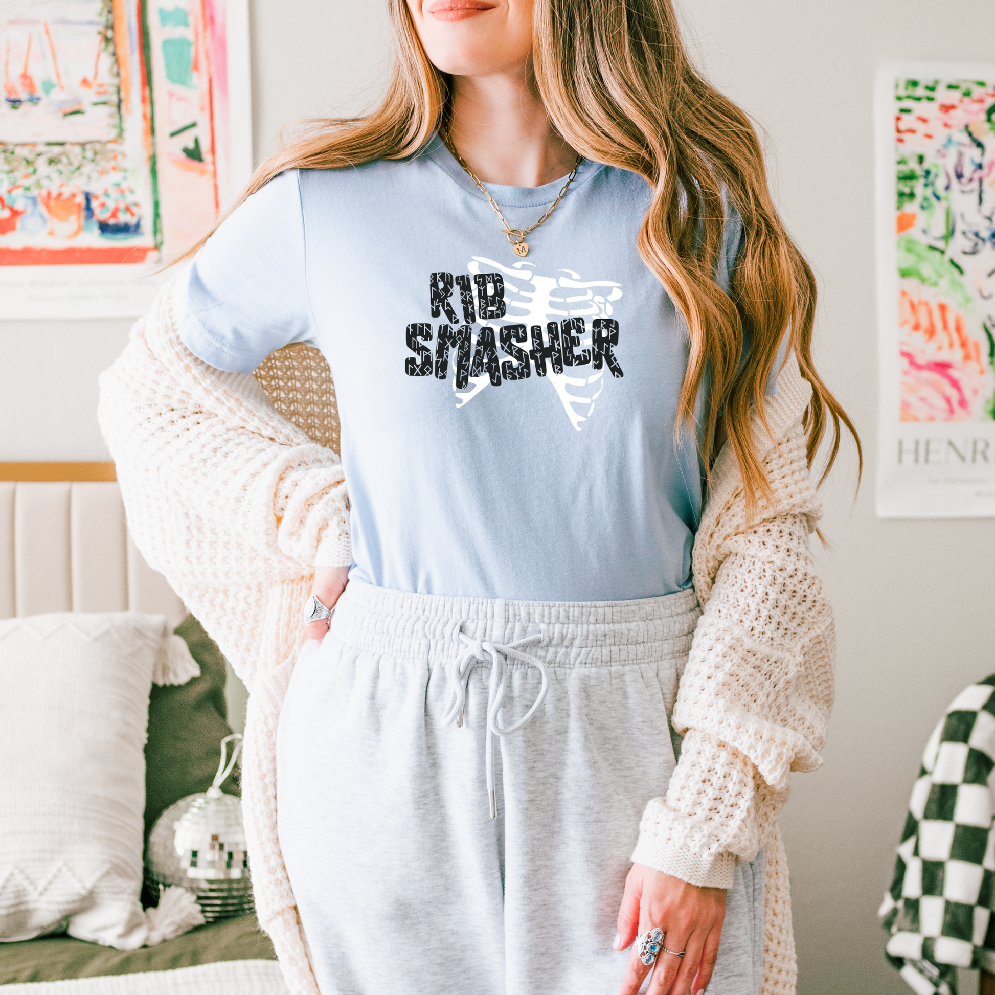 Person wearing a light blue sweatshirt with 'KID SMASHER' text in a casual setting.